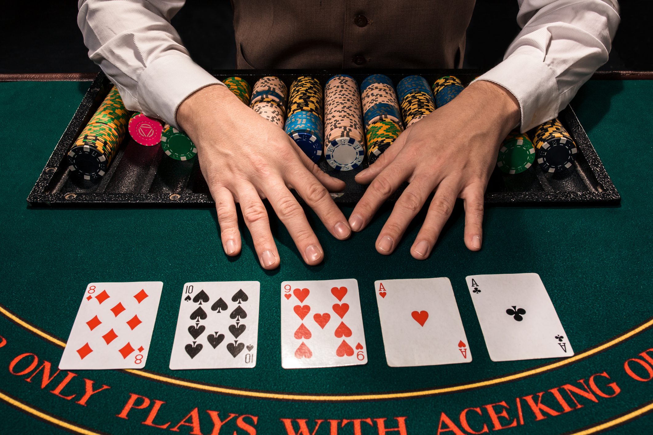 A poker player arranging chips and cards on the table.
